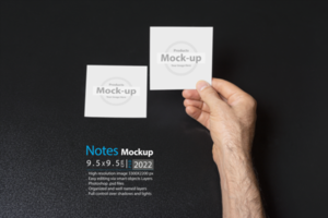 hand holding a blank note paper or image frame on dark background psd