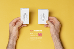 A man hands holding two pillboxes in front of yellow background psd