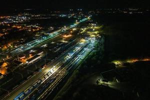 night aerial view over long railway freight trains with lots of wagons stand on parking photo