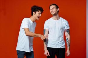 two friends in white t-shirts stand side by side isolated background photo
