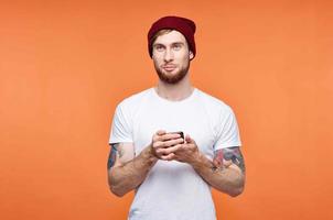 man in a white t-shirt with a phone in his hands in communication technology orange background photo