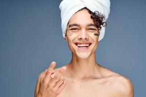 man with bare shoulders towel on head cream clean skin cosmetology photo
