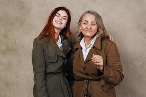 young and old woman are standing next to each other in a coat posing photo