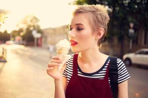 short haired woman eating ice cream outdoors in summer photo