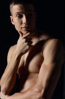 portrait of an athlete on a dark background training muscles model cropped view photo