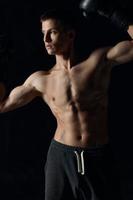 guy with a pumped-up torso gesturing with his hands on a black background boxing gloves photo