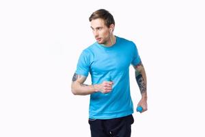 deportivo hombre con un tatuaje en su brazo en un azul camiseta y músculos culturismo aptitud foto