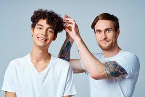 dos alegre amigos en blanco camisetas emociones estudio foto