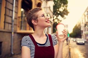 alegre mujer con un taza de bebida al aire libre relajante foto