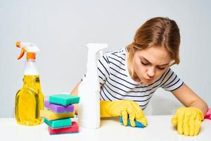 A cleaning lady sits at a table providing housekeeping services light background photo