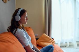 retrato de un mujer auricular a hogar en el sofá entretenimiento estilo de vida foto