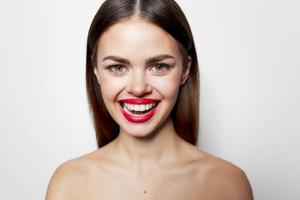 Cheerful woman with wide open smile red lips bared shoulders close-up photo