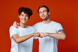 dos amigos en blanco camisetas abrazos comunicación rojo antecedentes foto