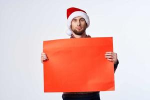 emotional man in New Year's clothes holding a banner holiday light background photo