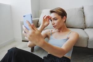 Woman blogger selfies on phone, selfies and online conversations for followers, teenager develops social media, freelancer from home photo