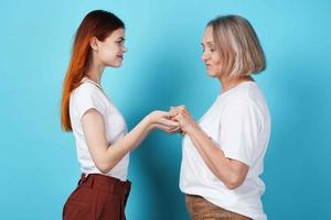 mamá y hija sostener manos en blanco camisetas familia juntos foto