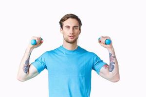 atleta con pesas haciendo ejercicio aptitud bombeado arriba brazo músculos tatuaje foto