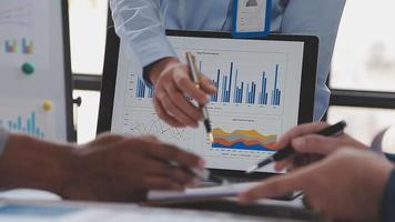 Financial analysts analyze business financial reports on a digital tablet planning investment project during a discussion at a meeting of corporate showing the results of their successful teamwork. video