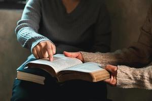 Small group of asian people praying worship believe. Teams of friends worship together before studying Holy bible. family praying together in church. Small group learning with prayer concept. photo