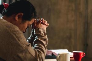 Christian life crisis prayer to god. Woman pray for god blessing to wishing have a better life. Woman hands praying to god with the bible. Begging for forgiveness and believe in goodness. photo