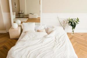 A cozy bed on the floor, a large mirror in a classic modern bedroom. Interior of the house photo