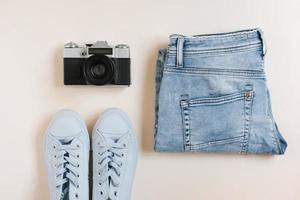 Accessories for urban travel. Jeans, sneakers, top view camera photo