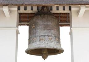 antiguo Iglesia campana aislado en blanco en el templo de lamphun, Tailandia foto