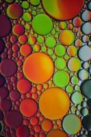 círculos de aceite multicolores en el agua, fondo colorido foto