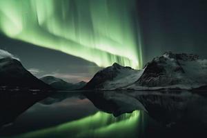 Aurora borealis en el Noruega. verde del Norte luces encima montañas. noche cielo con polar luces. noche invierno paisaje con Aurora foto