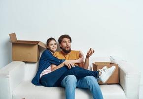 Young couple boxes with things on moving room interior photo