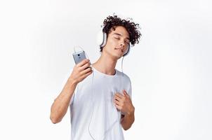 alegre chico en auriculares escucha a música gesticulando con su manos emociones foto