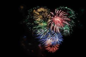 Multicolored fireworks heart in black sky, copy space photo