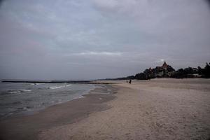landscape on a winter day on the beach in leba in Poland with a historic hotel photo