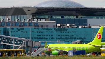 novosibirsk, ruso federación julio 15, 2022 - pasajero avión de s7 aerolíneas llegada a el aeropuerto. personas salir el avión en el escaleras. turismo y viaje concepto video