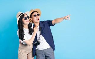 Asian couple traveling image  isolated on blue background photo