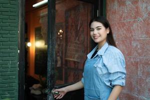 A young businesswoman who owns a pottery school Open the door to welcome students who love to learn pottery. photo