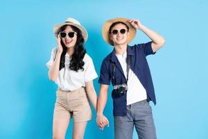 Asian couple traveling image  isolated on blue background photo