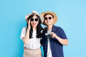 Asian couple traveling image  isolated on blue background photo