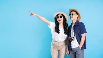 Asian couple traveling image  isolated on blue background photo