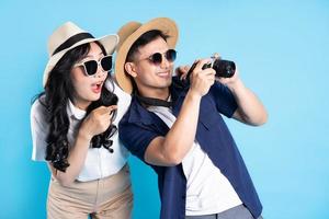 Asian couple traveling image  isolated on blue background photo