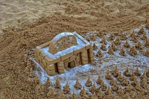 arena escultura en el playa en contra el fondo de el Oceano foto