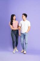 full body image of asian couple posing on purple background photo