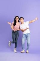full body image of asian couple posing on purple background photo