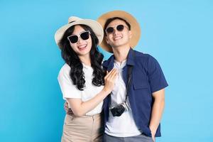 Asian couple traveling image  isolated on blue background photo