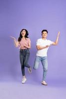 full body image of asian couple posing on purple background photo