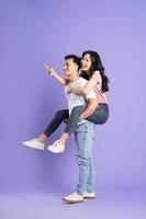 full body image of asian couple posing on purple background photo