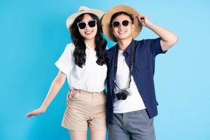 Asian couple traveling image  isolated on blue background photo