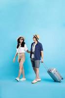 Asian couple traveling image  isolated on blue background photo