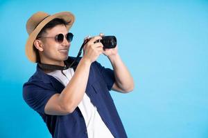 travel asian man portrait, isolated on blue background photo