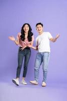 full body image of asian couple posing on purple background photo